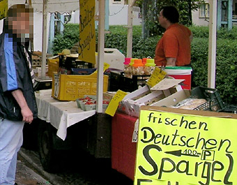 Marktstand mit Pöbler (links) und Schild mit Pfeil